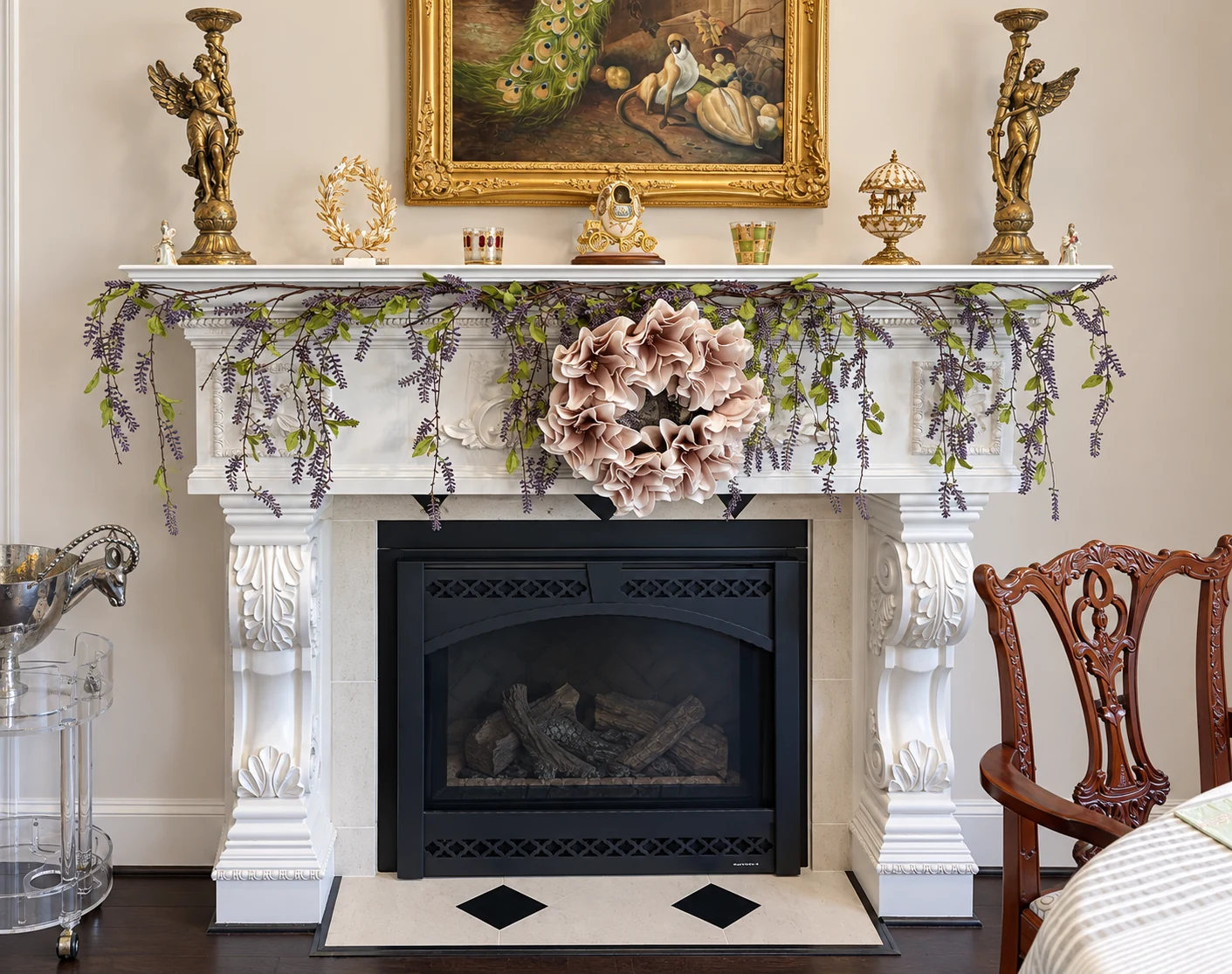 White fireplace mantel with carved details, a dark firebox, and a pale hearth
